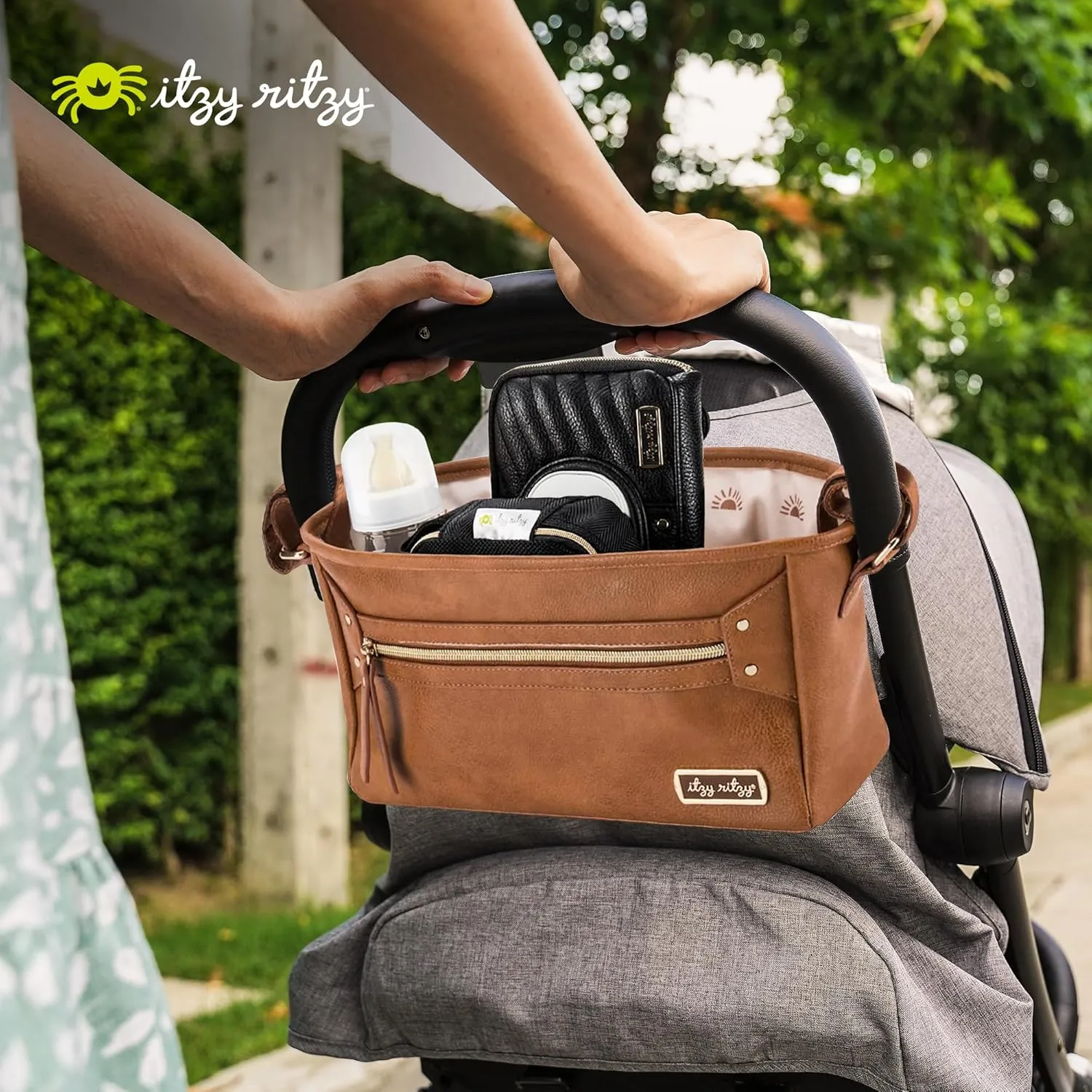 Itzy Ritzy Adjustable Stroller Caddy and Organizer Bag Featuring Front Zippered Pocket, 2 Built-in Interior Pockets & Adjustable Straps to Fit Nearly Any Stroller (Cognac)